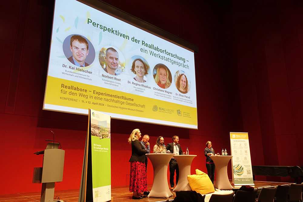 Podiumsdiskussion bei der Reallaborkonferenz in Dresden. Personen stehen auf der Bühne.