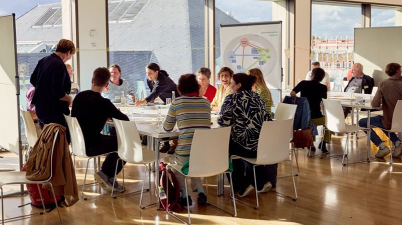 Menschen bei einem Workshop in einem hellen Raum.